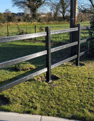 plastic fence installed in a garden beside a stone gate pillar