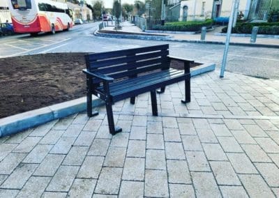 Public seating outdoor bench secured to the ground made from black recycled plastic